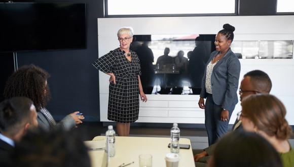 two women presenting in a boardroom