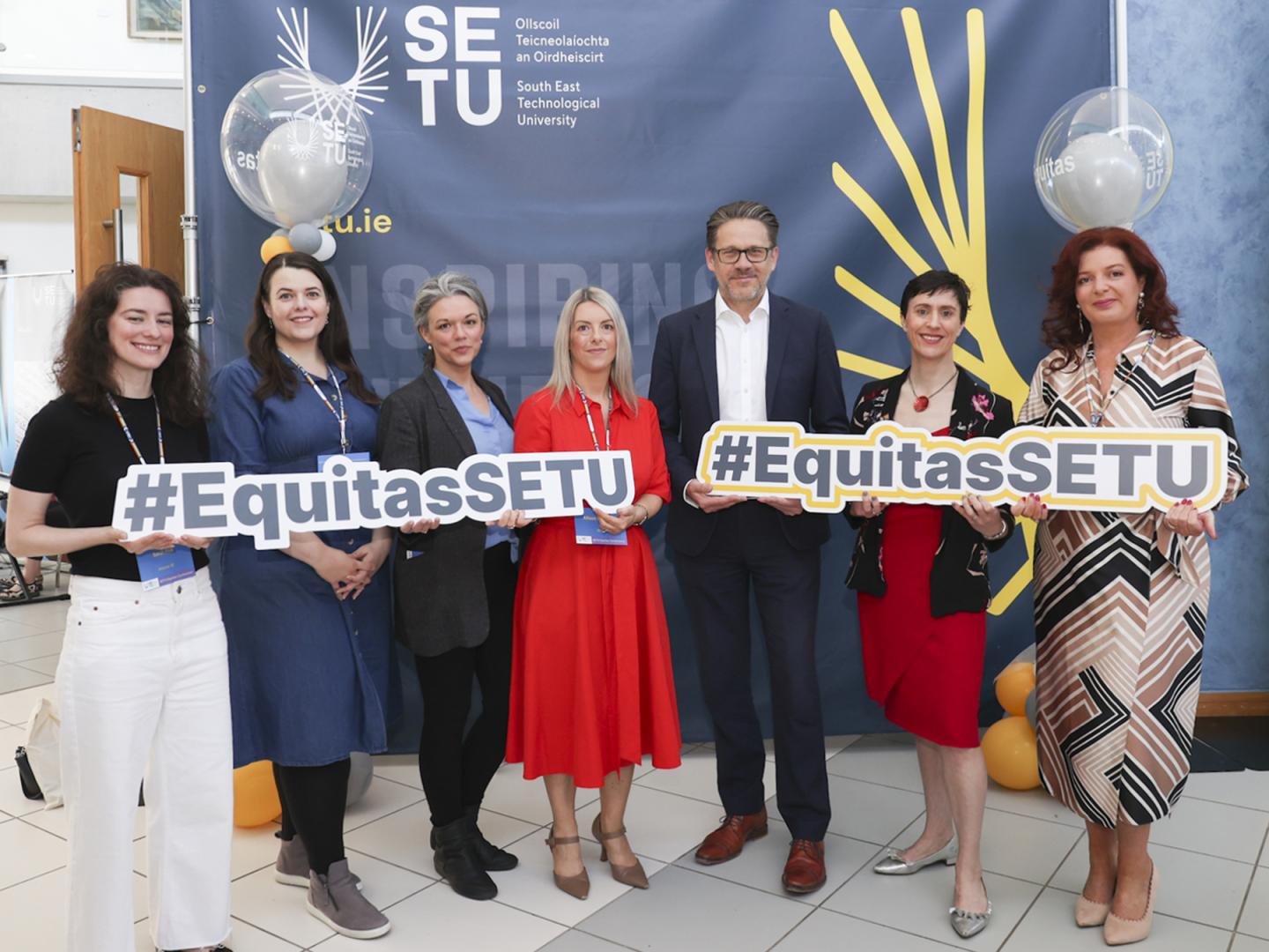 Six women and a man holding signs saying #EquitasSETU