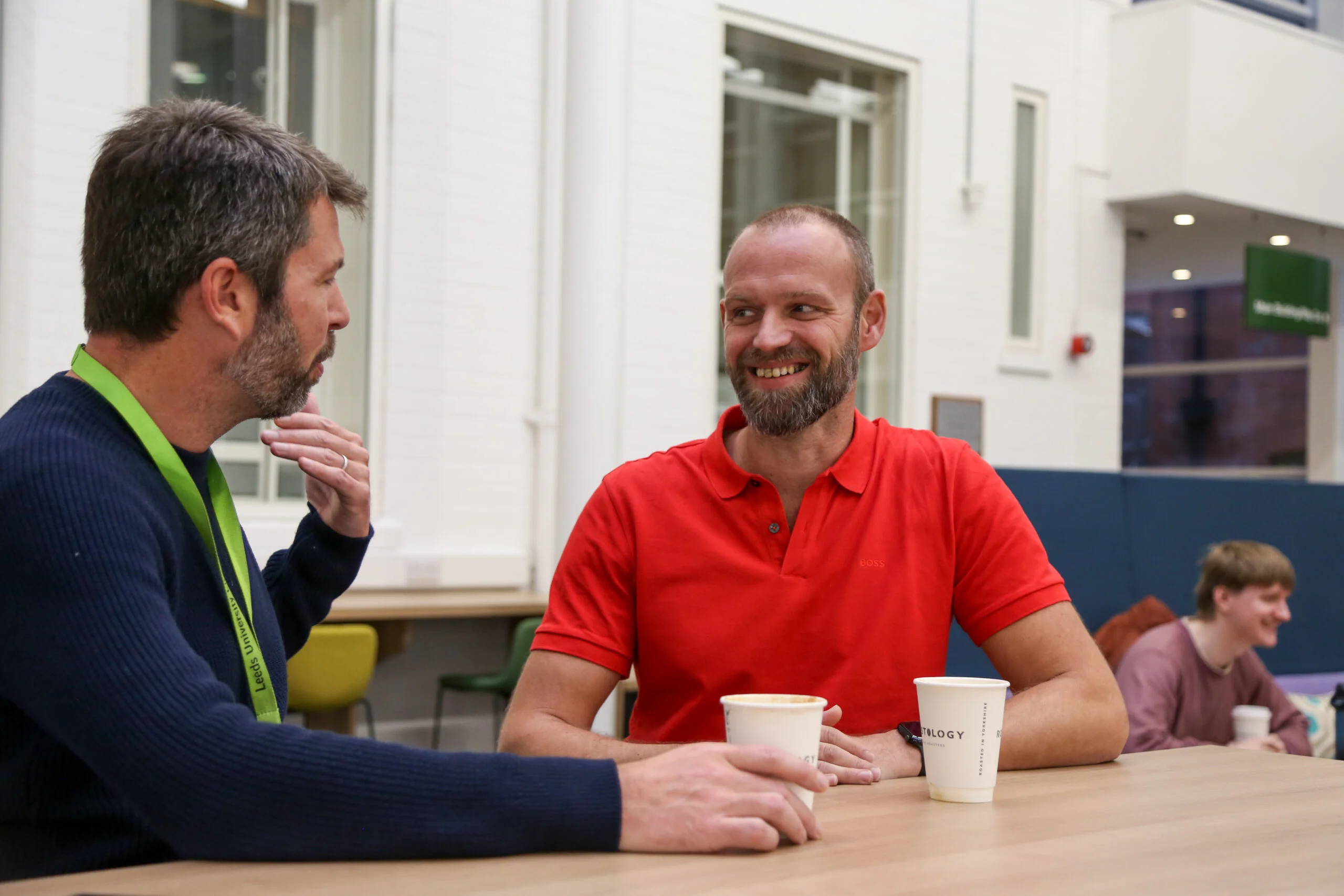 Two people talking seated at a table