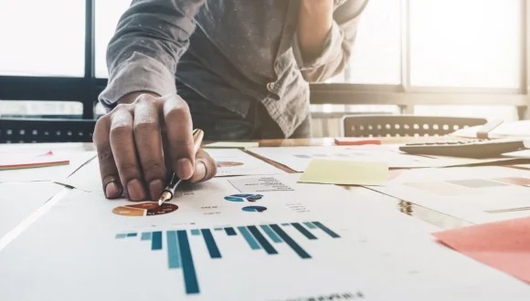 A person looking at several graphs on a piece of paper