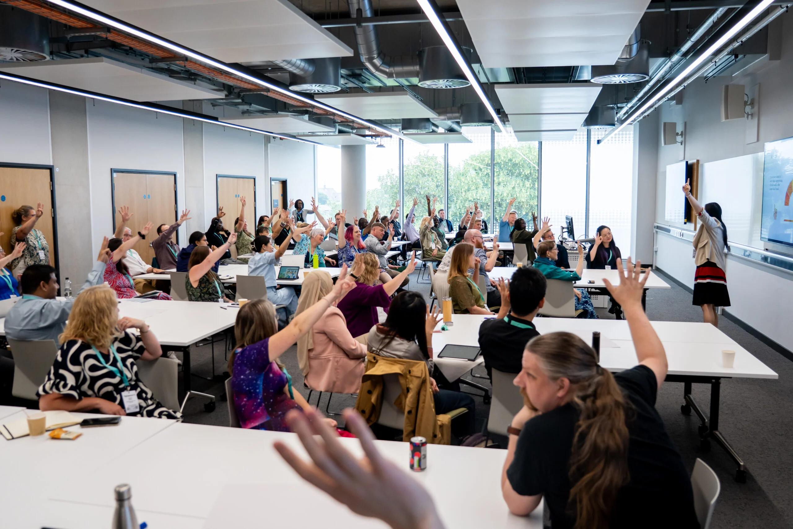 Hands raised in a conference room