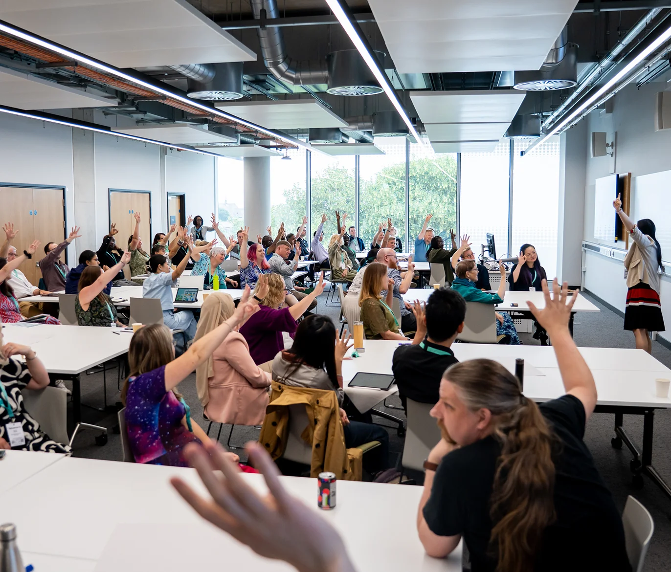 Conference workshop with delegates with their hands up